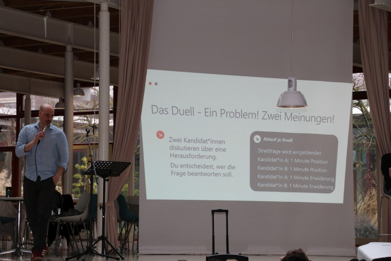 Lehrer Mario Walter (links) stellt anhand einer Folie die Regeln des Rededuells vor.