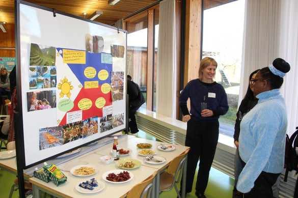 Auszubildende der generalistischen Pflegeausbildung mit Plakaten zur Pflege in ihren Heimatländern bzw. anderen Ländern