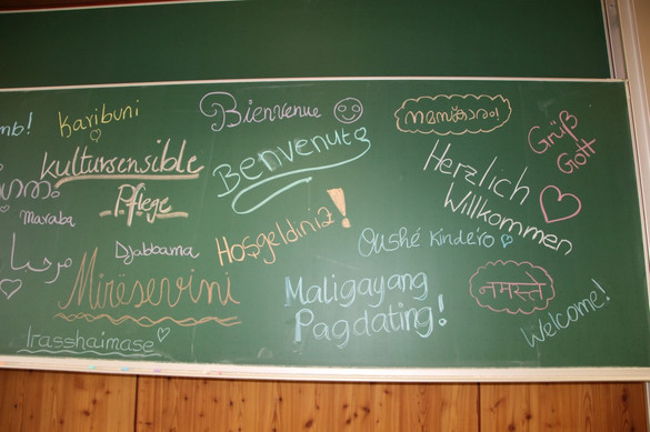 Tafel mit Begrüßungstext zur Ausstellung zur interkulturellen Pflege, erstellt von Auszubildenden der generalistischen Pflegeausbildung