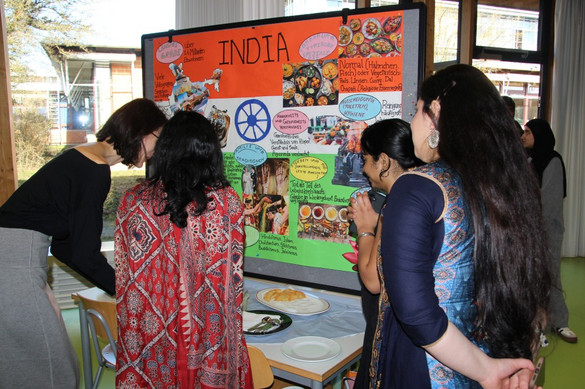 Auszubildende der generalistischen Pflegeausbildung mit Plakaten zur Pflege in ihren Heimatländern bzw. anderen Ländern