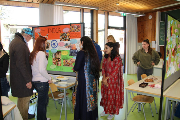 Auszubildende der generalistischen Pflegeausbildung mit Plakaten zur Pflege in ihren Heimatländern bzw. anderen Ländern