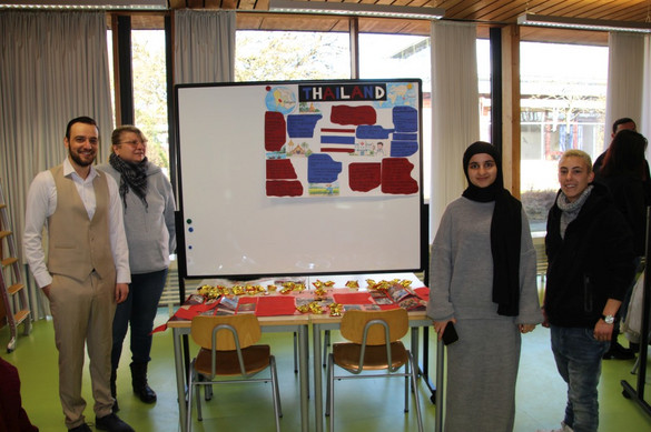 Auszubildende der generalistischen Pflegeausbildung mit Plakaten zur Pflege in ihren Heimatländern bzw. anderen Ländern