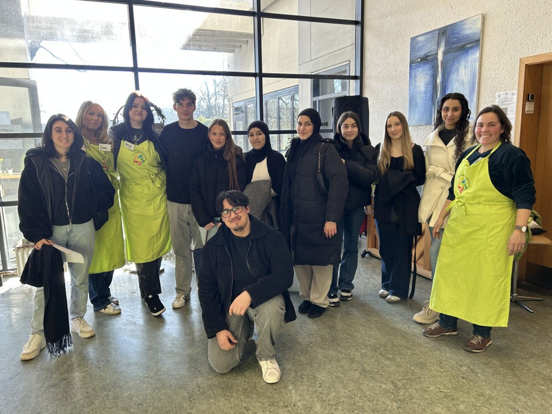Gruppenfoto von Schüler:innen der Klasse 1BKSP1 mit Lehrerin Kerstin Schmidt bei der Vesperkirche