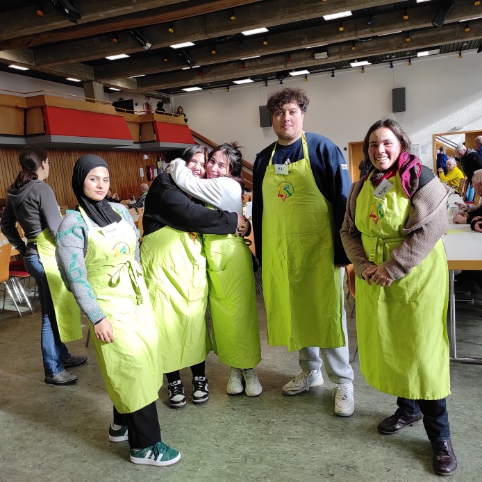 Gruppenfoto von Schüler:innen der Klasse 1BKSP2 mit Lehrerin Kerstin Schmidt bei der Vesperkirche